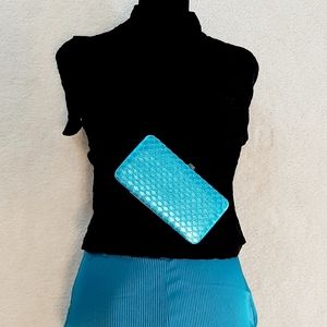 Teal pants, teal clutch, & black shirt outfit